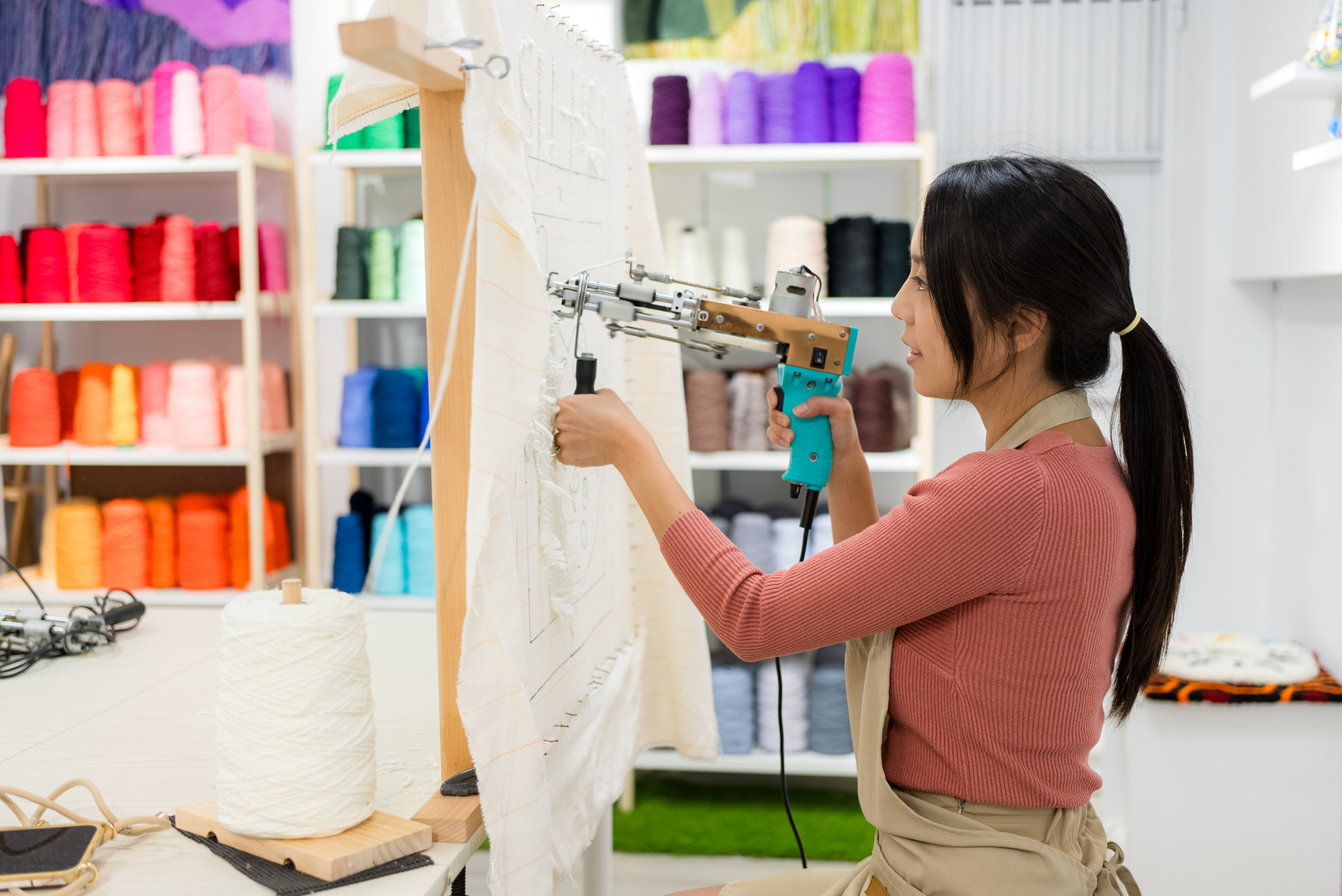 Woman make of tufting carpet at studio